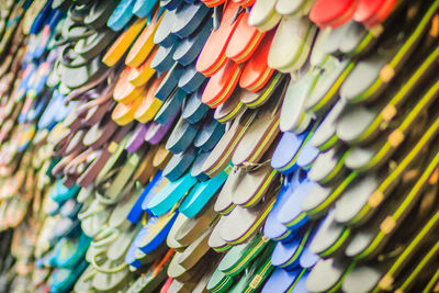 Low angle view of multi colored slippers hanging in market for sale