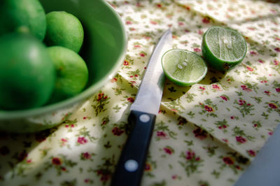 High angle view of knife with lemons on table