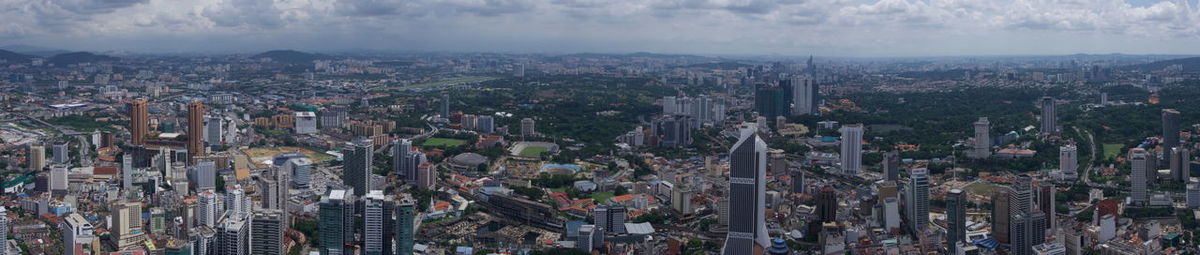 Panoramic view of cityscape against cloudy sky