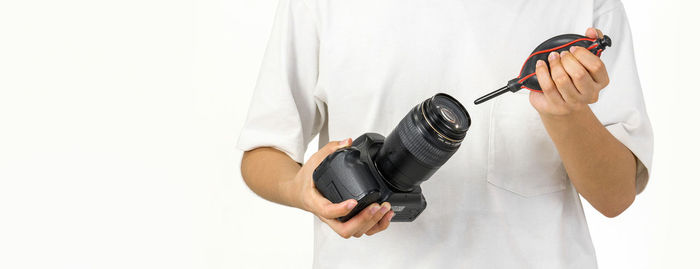 Close-up of hand holding camera against white background