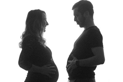 Side view of couple standing against white background