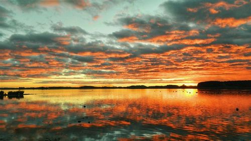 Scenic view of sea against cloudy sky at sunset