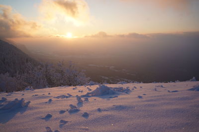 Scenic view of snow covered landscape against sky during sunset