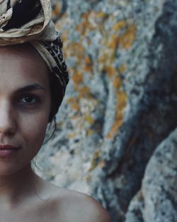 Close-up portrait of woman against rock