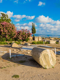 Scenic view of rocks by trees against blue sky