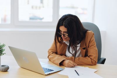 Young woman using laptop at office