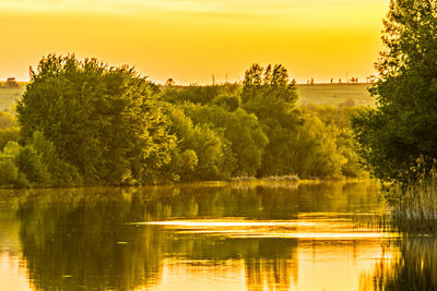 Scenic view of lake against sky at sunset