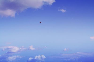 Distant view of hang gliders flying in sky