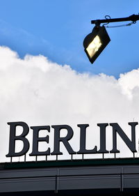 Low angle view of information sign against sky