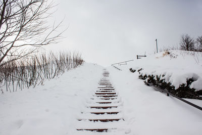 Scenic view of snow covered field against sky