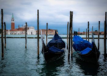 Boats moored in canal against sky