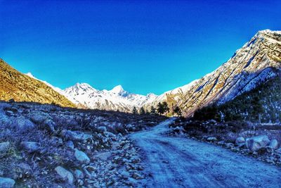 Scenic view of snowcapped mountains against clear blue sky