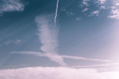 Low angle view of vapor trail against blue sky