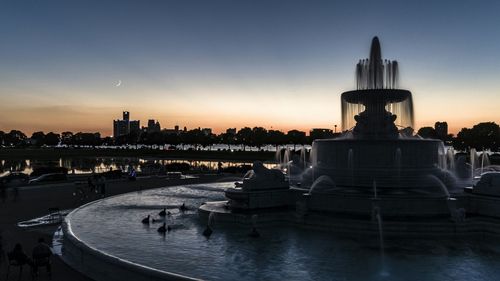 View of fountain in city at dusk