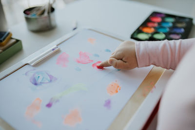 Midsection of girl painting on paper