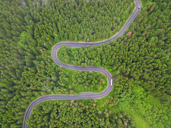 Aerial view of countryside road passing through the forest and mountain