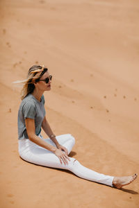 Side view of woman sitting on beach