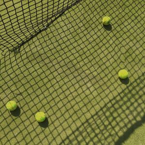 High angle view of tennis balls on grassy field in court