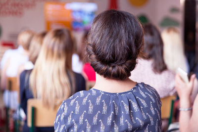 Rear view of woman sitting in classroom