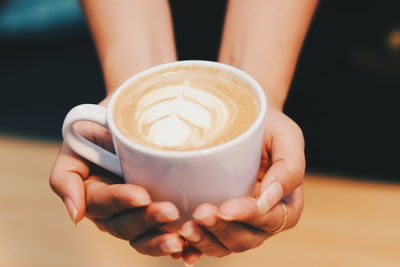 Cropped image of hand holding coffee cup