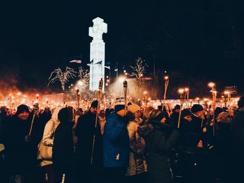 People on illuminated street lights at night