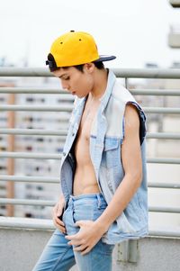 Young man standing by railing