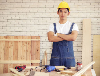 Portrait of senior man standing against wall