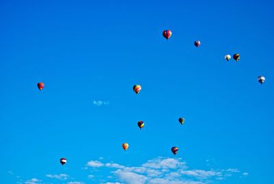 Low angle view of hot air balloons against blue sky