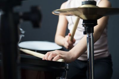 Midsection of person playing drums and cymbal