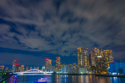 Illuminated cityscape against sky at night