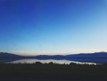 Scenic view of lake against clear blue sky