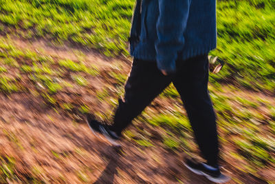 Low section of man standing on grassy field