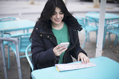 Young woman using mobile phone in winter