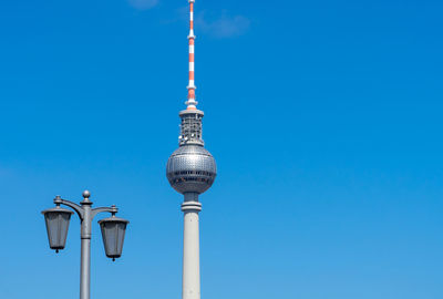 Low angle view of communications tower against blue sky