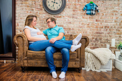 Full length of a couple sitting on floor