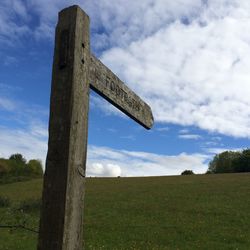 View of grassy field against cloudy sky