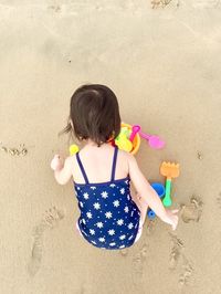 Directly above shot of baby girl playing with toys at beach