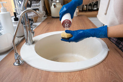 Low section of person washing hands in bathroom