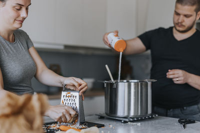 Couple in kitchen preparing food together