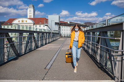 Man standing on bridge against sky