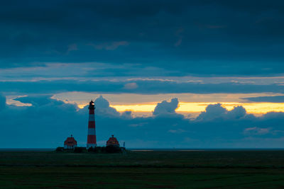 Tower on field against sky during sunset