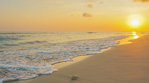 Scenic view of beach against sky during sunset