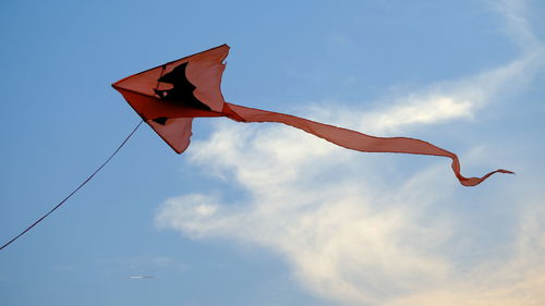 Low angle view of kites flying against sky