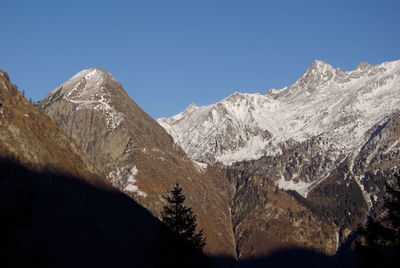 Scenic view of snowcapped mountains against clear blue sky