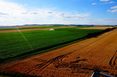 Scenic view of field against cloudy sky