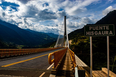 Information sign by road against sky