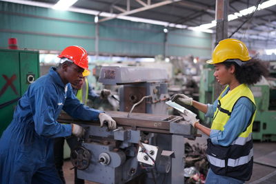 Industrial engineers in hard hats.work at the heavy industry manufacturing factory.