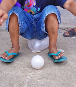 Low section of boy sitting on balloon at playground