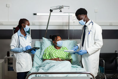 Doctors wearing mask examining patient at clinic