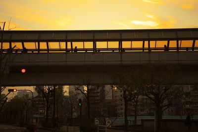 Illuminated city against sky at sunset